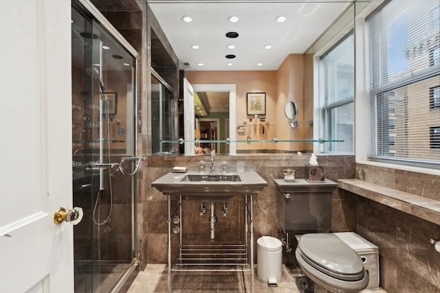 bathroom with a shower with shower door, tile walls, and toilet