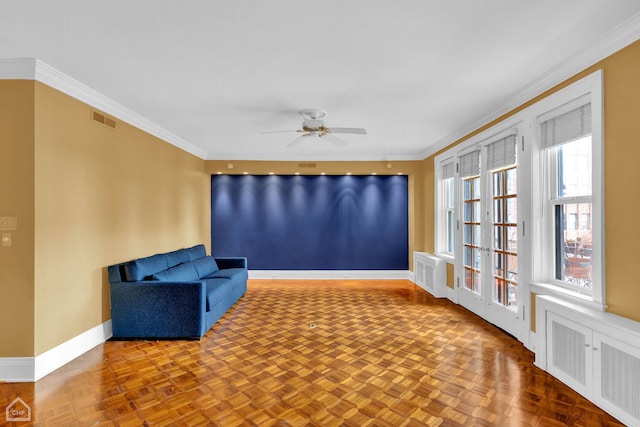 sitting room featuring ceiling fan, ornamental molding, and parquet flooring