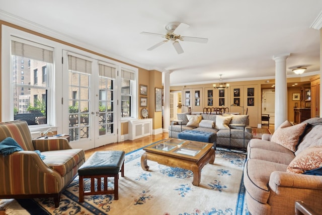 living room with ceiling fan with notable chandelier, ornamental molding, ornate columns, and light wood-type flooring