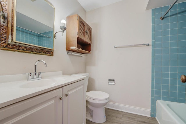 full bathroom featuring vanity, hardwood / wood-style flooring, toilet, and tiled shower / bath