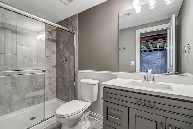 bathroom with visible vents, wainscoting, a stall shower, and toilet