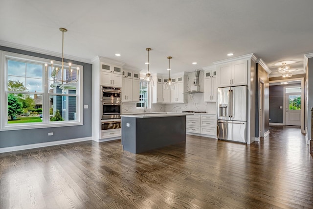 kitchen featuring ornamental molding, appliances with stainless steel finishes, wall chimney exhaust hood, and a warming drawer