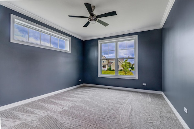 carpeted spare room with a ceiling fan, baseboards, and ornamental molding