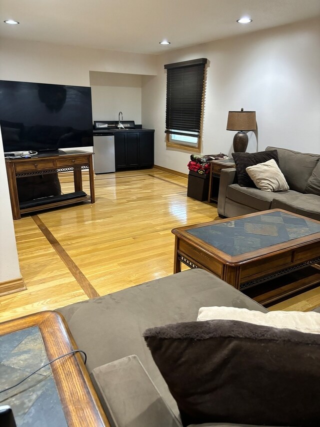 living room featuring sink and light hardwood / wood-style floors