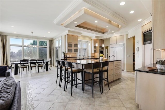 tiled dining area with sink, crown molding, and a raised ceiling