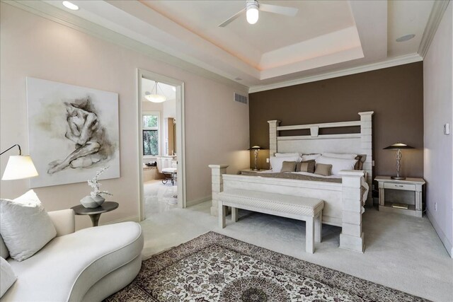 bedroom featuring carpet floors, a tray ceiling, ceiling fan, and ornamental molding