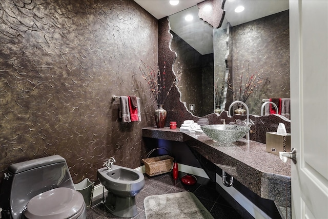 bathroom with a bidet, tile patterned floors, toilet, and sink