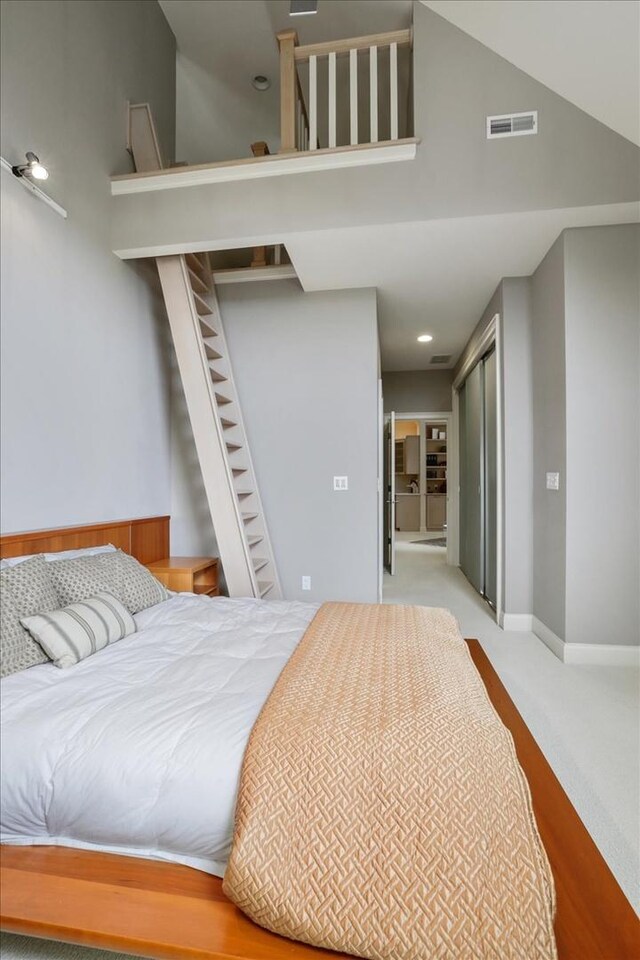 carpeted bedroom with a high ceiling