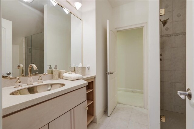 bathroom with vanity, tile patterned flooring, and tiled shower