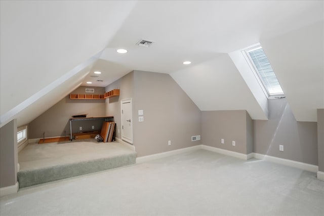 bonus room with carpet and vaulted ceiling with skylight