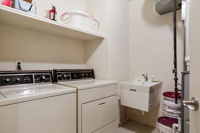 washroom featuring light tile patterned flooring, sink, and independent washer and dryer