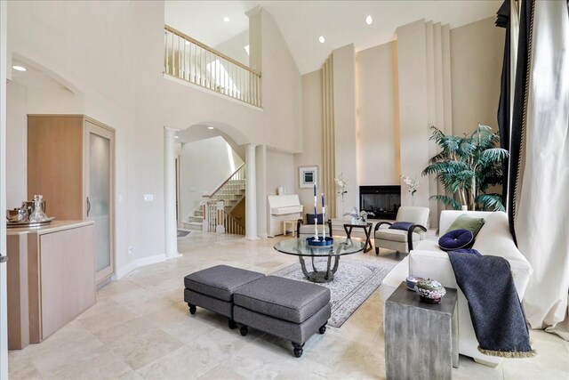 living room with light tile patterned floors and a towering ceiling