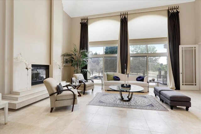 living area featuring light tile patterned floors and a towering ceiling