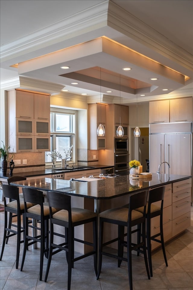 kitchen featuring decorative backsplash, pendant lighting, ornamental molding, and a tray ceiling