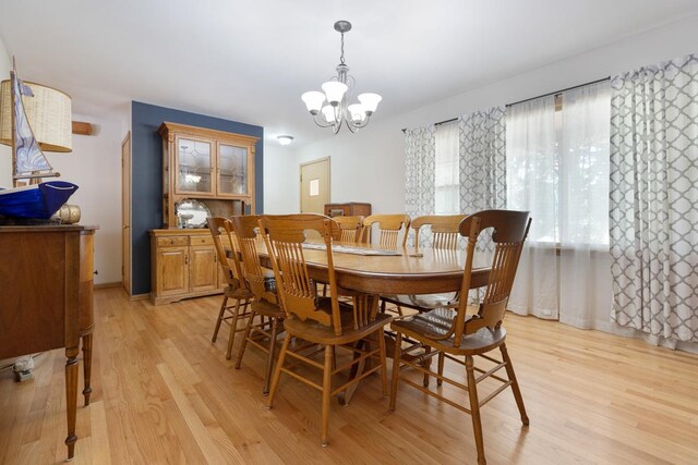 dining space featuring light hardwood / wood-style floors and a chandelier