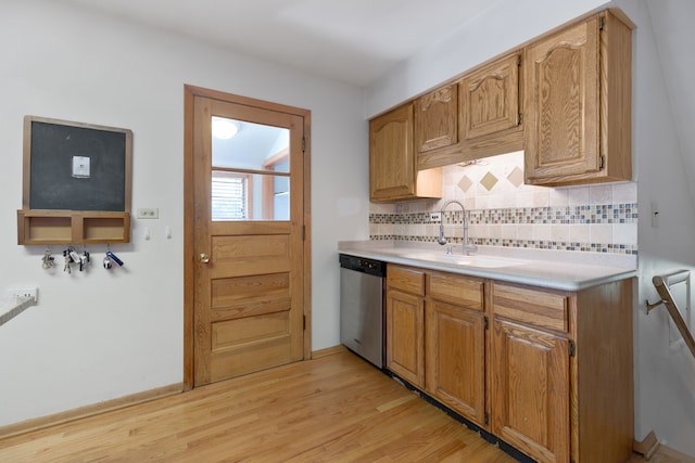 kitchen featuring stainless steel dishwasher, sink, light hardwood / wood-style flooring, and tasteful backsplash