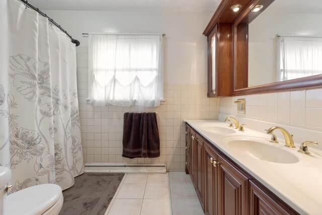 bathroom with tile patterned flooring, tile walls, dual vanity, and toilet