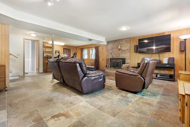 living room with wood walls, tile patterned floors, and a fireplace