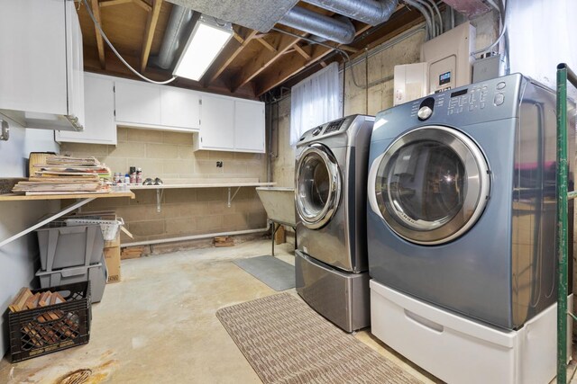 laundry area featuring washing machine and dryer and cabinets