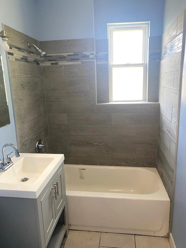 bathroom featuring tiled shower / bath, vanity, and tile patterned flooring