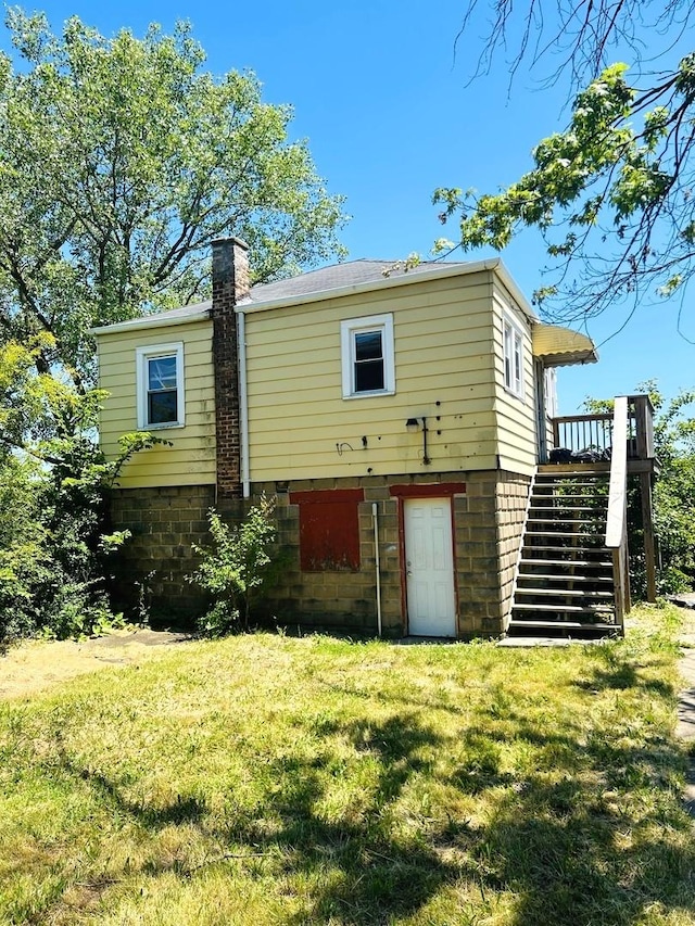 rear view of house with a deck and a lawn