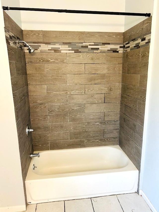 bathroom with tiled shower / bath combo and tile patterned flooring