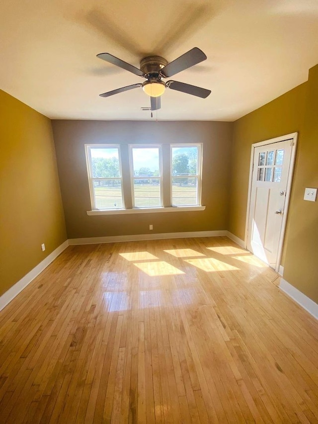 spare room with ceiling fan and light wood-type flooring