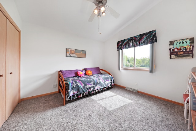 carpeted bedroom featuring ceiling fan, a closet, and vaulted ceiling