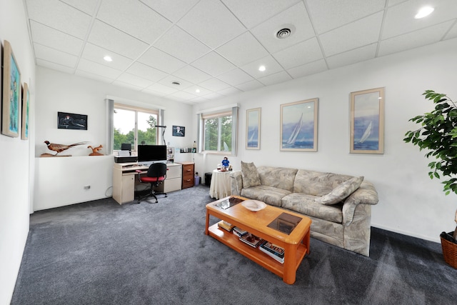 carpeted living room featuring a drop ceiling