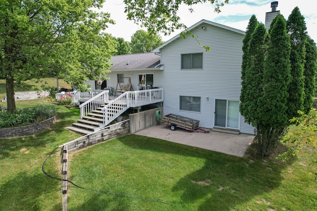 rear view of property with a patio area, a yard, and a wooden deck