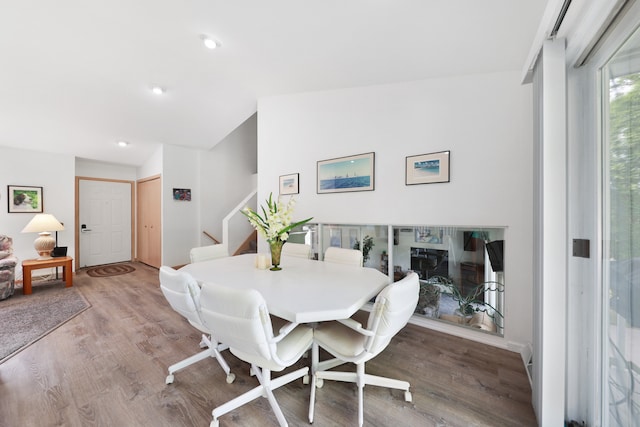 dining area with hardwood / wood-style floors and vaulted ceiling