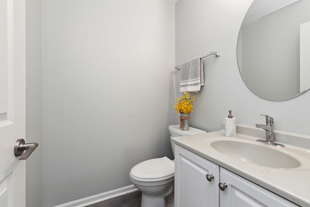 bathroom featuring vanity, hardwood / wood-style flooring, and toilet