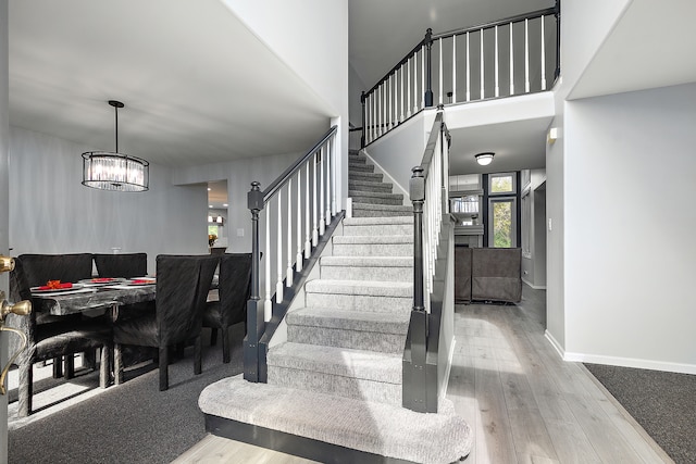 stairway with a notable chandelier and hardwood / wood-style flooring