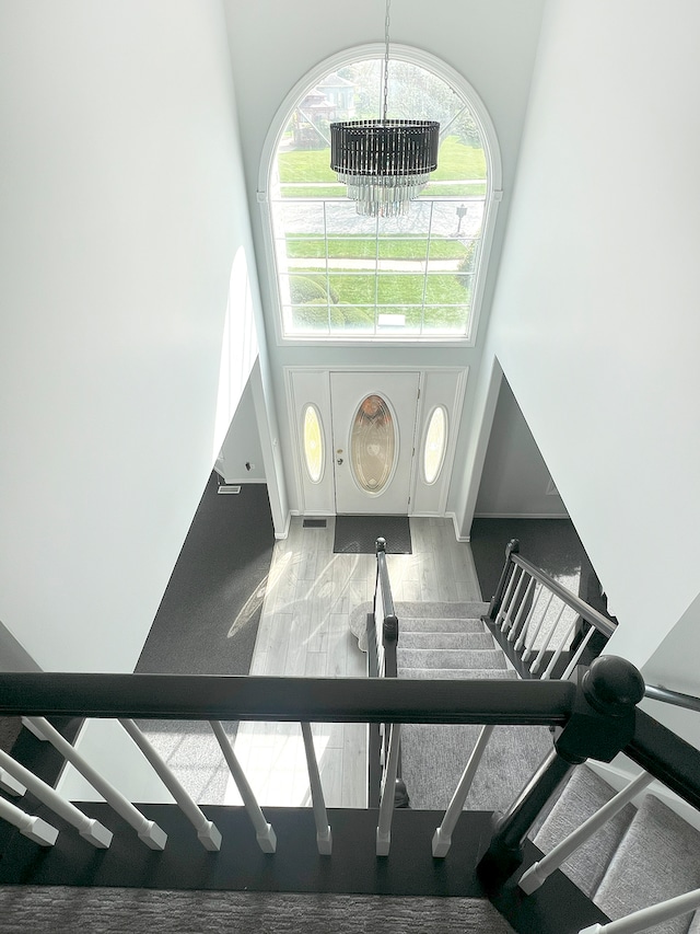 foyer entrance featuring a towering ceiling and an inviting chandelier