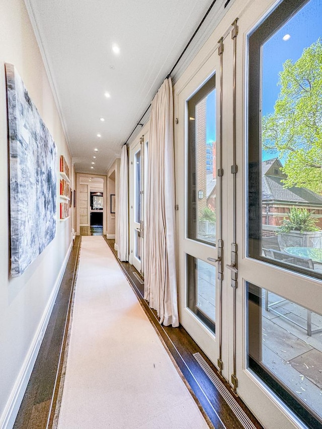 corridor with recessed lighting, crown molding, baseboards, and wood finished floors