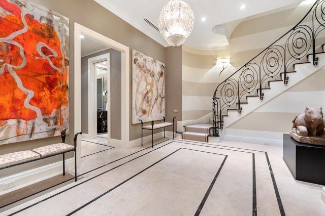 stairs with a chandelier and ornamental molding