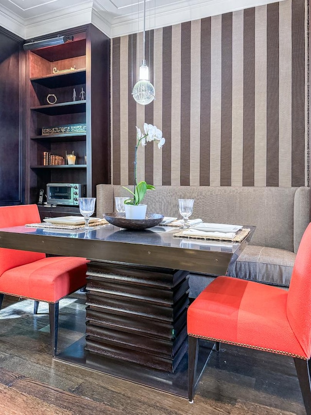 dining area featuring wallpapered walls, crown molding, built in shelves, and wood finished floors