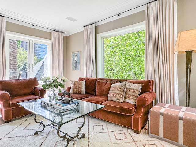 living area with visible vents, a healthy amount of sunlight, and crown molding