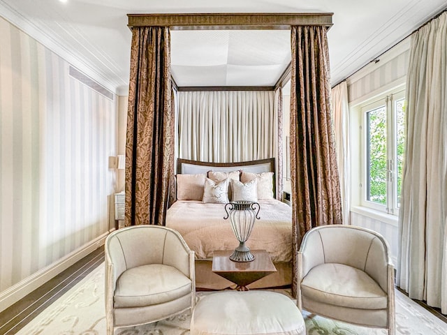 bedroom with wood finished floors, baseboards, ornamental molding, and wallpapered walls