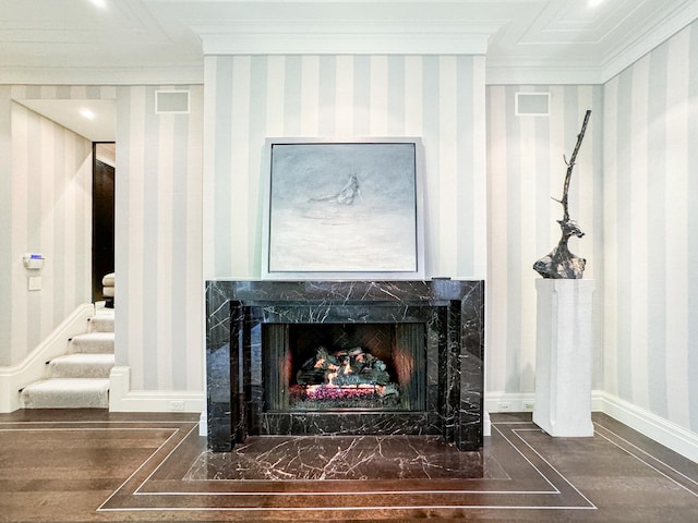 room details with wood finished floors, a high end fireplace, crown molding, wallpapered walls, and baseboards