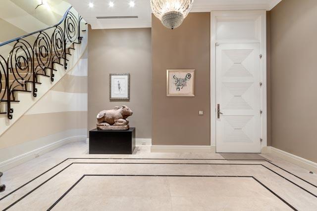 foyer entrance with stairs, a notable chandelier, and baseboards