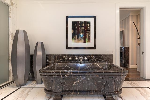 bathroom featuring a freestanding bath and marble finish floor