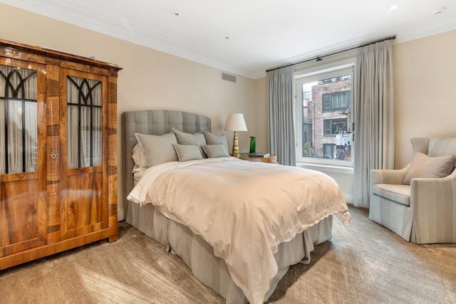 bedroom featuring light carpet, visible vents, and ornamental molding