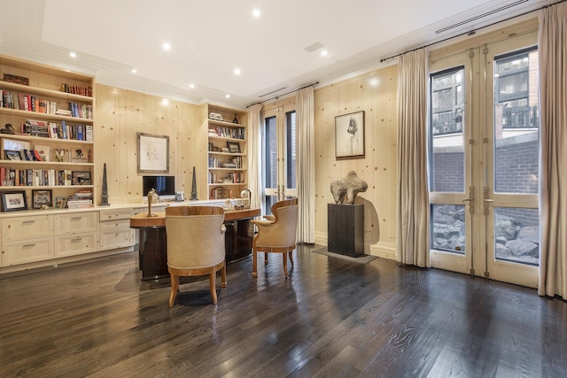 home office featuring built in features, dark wood-style floors, built in desk, french doors, and crown molding