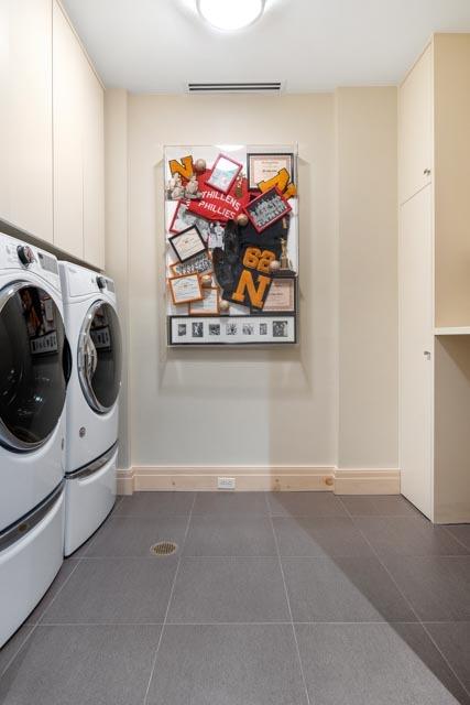 laundry area featuring visible vents, baseboards, washer and clothes dryer, dark tile patterned floors, and laundry area