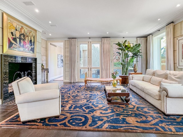 living area featuring recessed lighting, a high end fireplace, wood finished floors, and crown molding