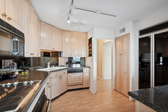 kitchen with dark countertops, paneled dishwasher, visible vents, and stovetop