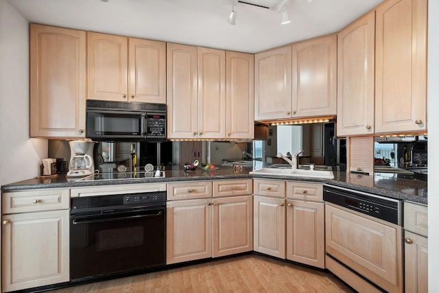 kitchen featuring light wood-type flooring, light brown cabinets, a sink, and black appliances