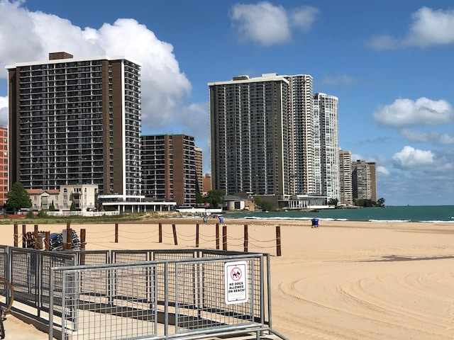 view of property featuring a beach view, a water view, and a city view