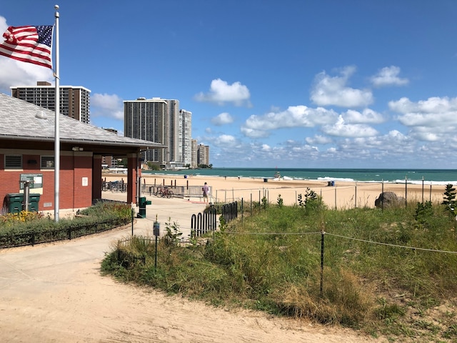 water view featuring fence and a view of the beach